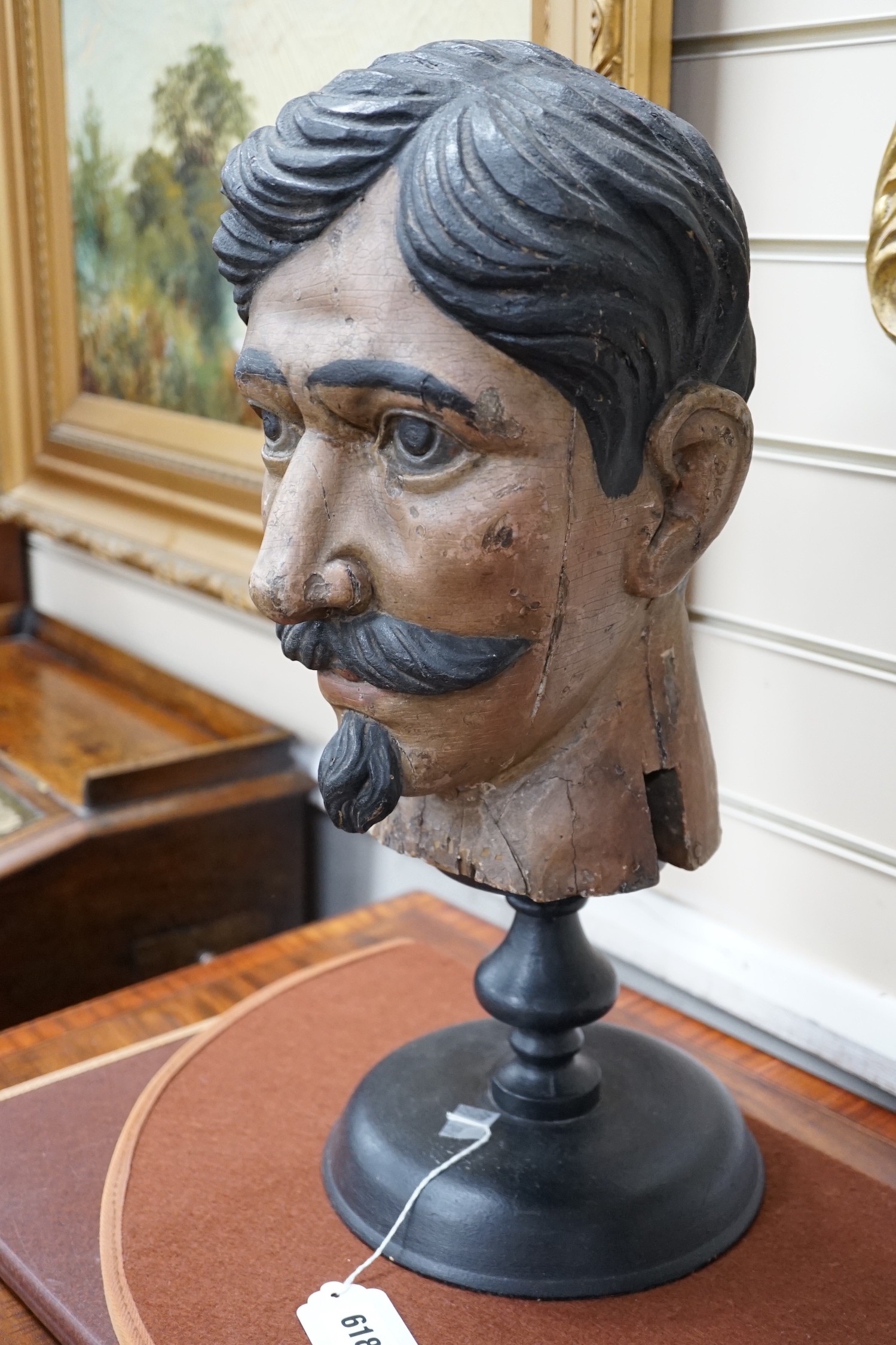 Two 20th century Italian carved and painted wooden heads on stands, 47cm